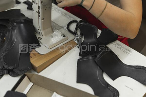 在一个皮革车间里,缝纫机正在用手操作鞋子的皮革细节。